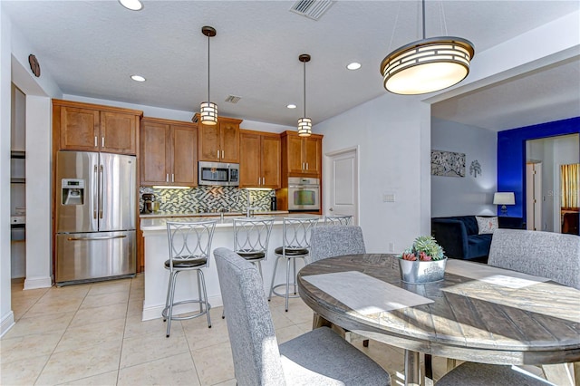 tiled dining area with a textured ceiling and sink