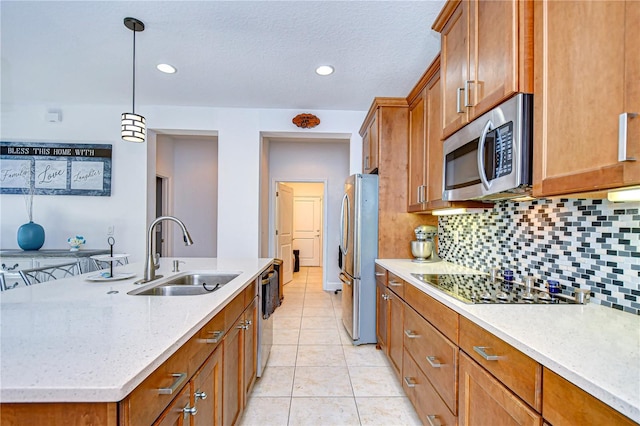 kitchen featuring pendant lighting, sink, an island with sink, appliances with stainless steel finishes, and light tile patterned flooring