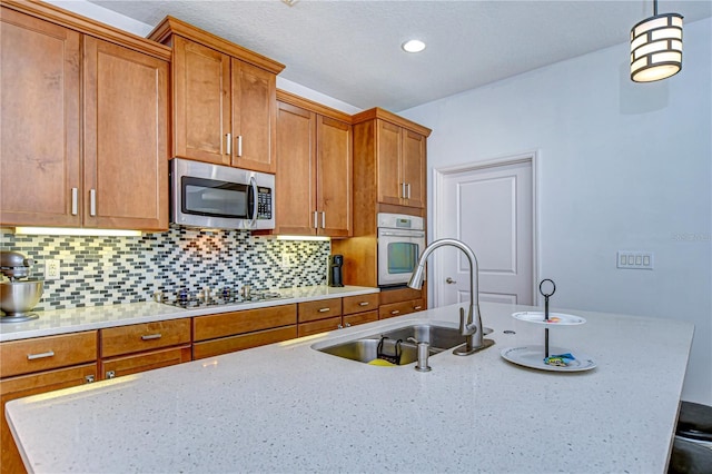 kitchen with decorative backsplash, wall oven, black electric cooktop, sink, and pendant lighting