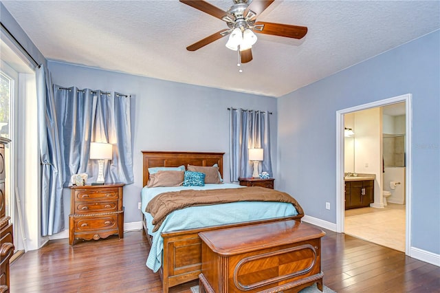 bedroom featuring a textured ceiling, ensuite bath, ceiling fan, and dark hardwood / wood-style floors