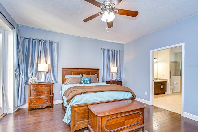 bedroom with dark hardwood / wood-style floors, ceiling fan, a textured ceiling, and ensuite bath