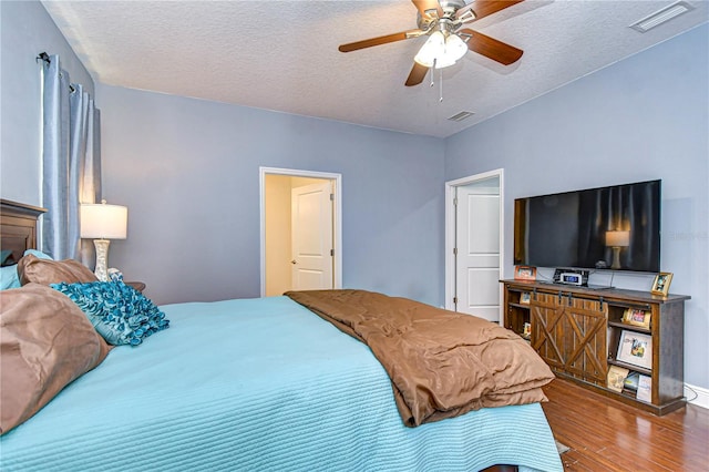 bedroom with hardwood / wood-style floors, a textured ceiling, and ceiling fan