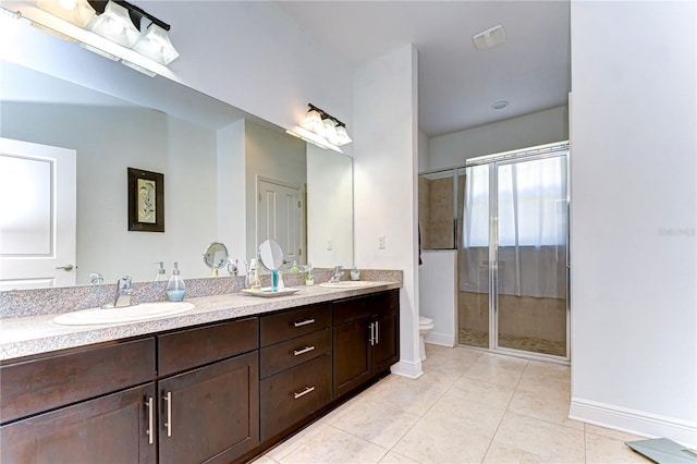 bathroom with tile patterned floors, vanity, toilet, and walk in shower