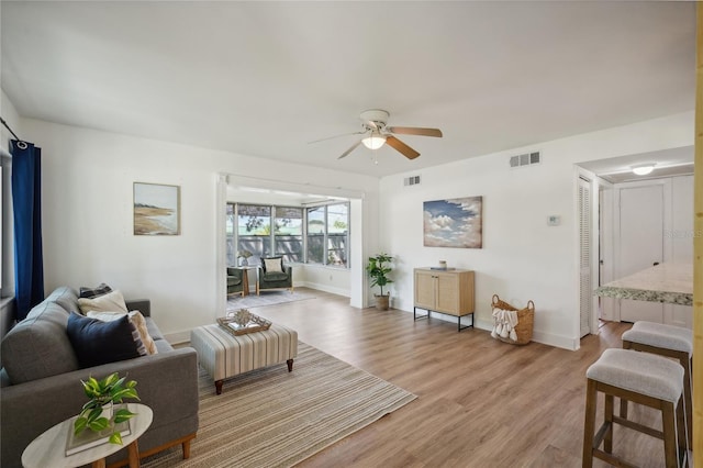 living room with light hardwood / wood-style floors and ceiling fan