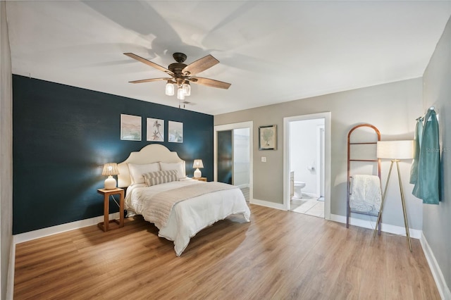 bedroom with ceiling fan, light hardwood / wood-style flooring, and ensuite bath