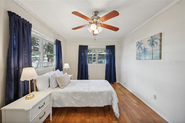 bedroom with hardwood / wood-style floors, ceiling fan, and ornamental molding