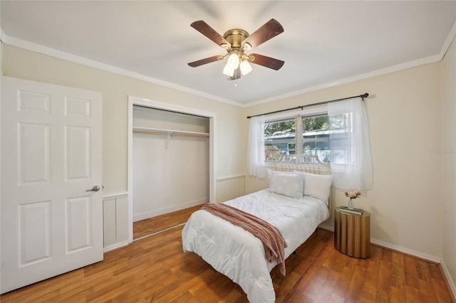 bedroom featuring crown molding, ceiling fan, a closet, and hardwood / wood-style floors