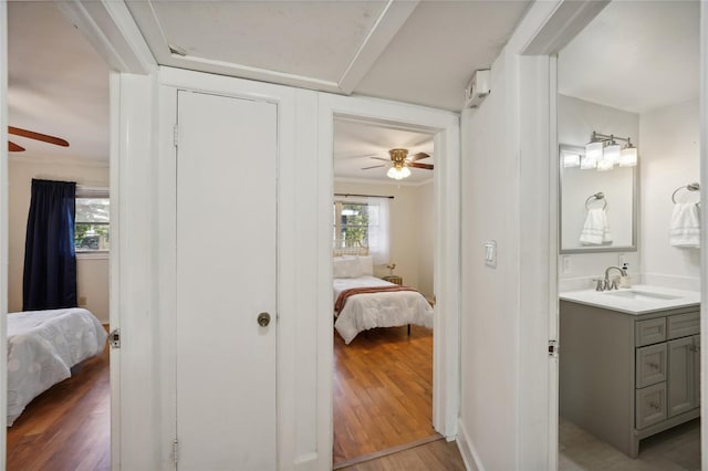 bathroom featuring ceiling fan, crown molding, vanity, and hardwood / wood-style flooring