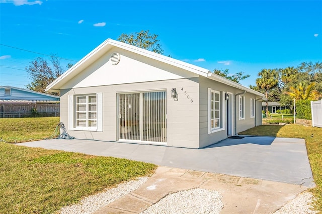 rear view of house with a lawn and a patio area