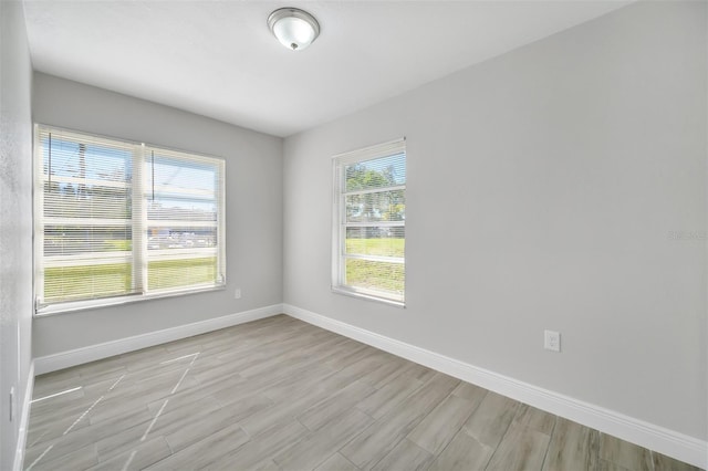 spare room with plenty of natural light and light hardwood / wood-style flooring