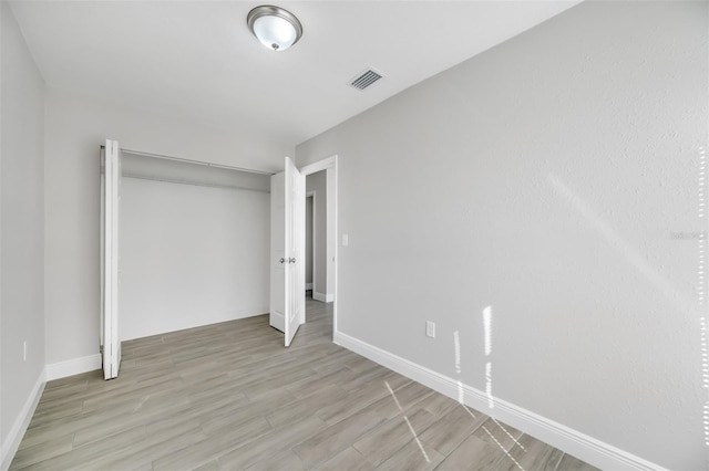 unfurnished bedroom featuring light wood-type flooring and a closet