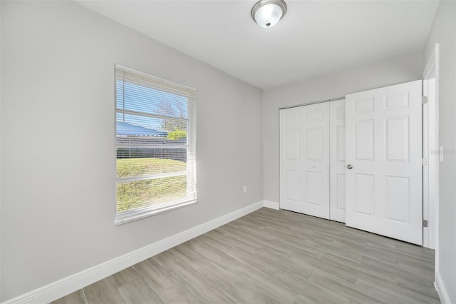 unfurnished bedroom featuring a closet and light hardwood / wood-style floors