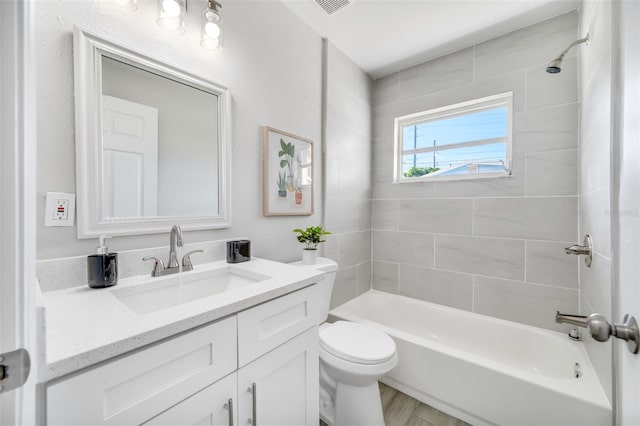 full bathroom featuring hardwood / wood-style floors, vanity, toilet, and tiled shower / bath