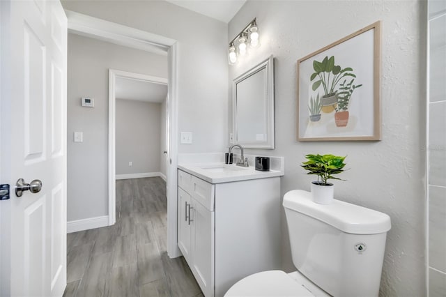 bathroom with vanity, hardwood / wood-style flooring, and toilet