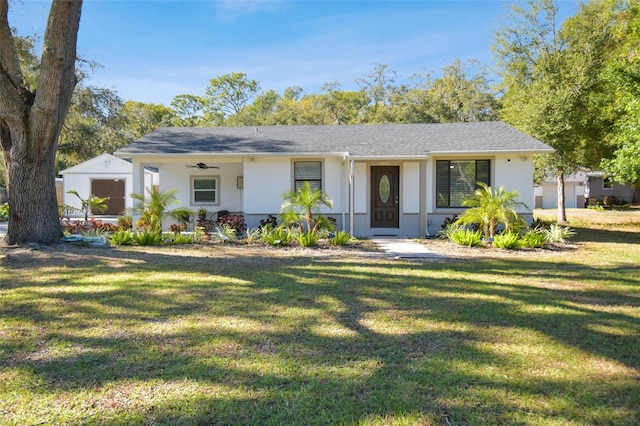 single story home featuring ceiling fan and a front lawn