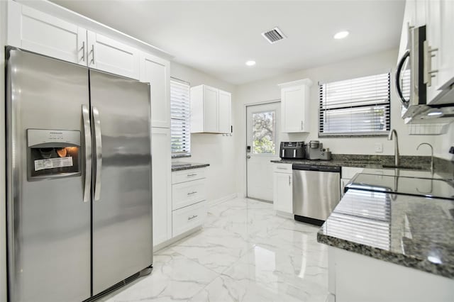 kitchen featuring white cabinetry, sink, dark stone counters, and appliances with stainless steel finishes