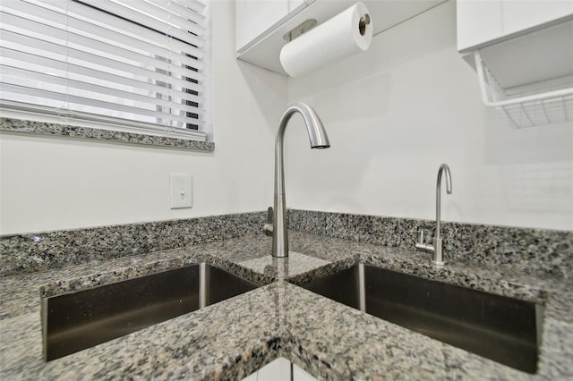 kitchen featuring white cabinetry, sink, and dark stone counters