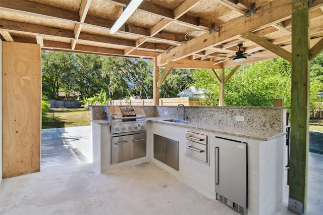 view of patio / terrace with an outdoor kitchen, a grill, sink, and ceiling fan