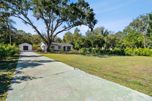 view of front of property featuring a garage, an outbuilding, and a front yard