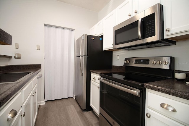 kitchen with stainless steel appliances, dark countertops, white cabinetry, and dark wood-style floors