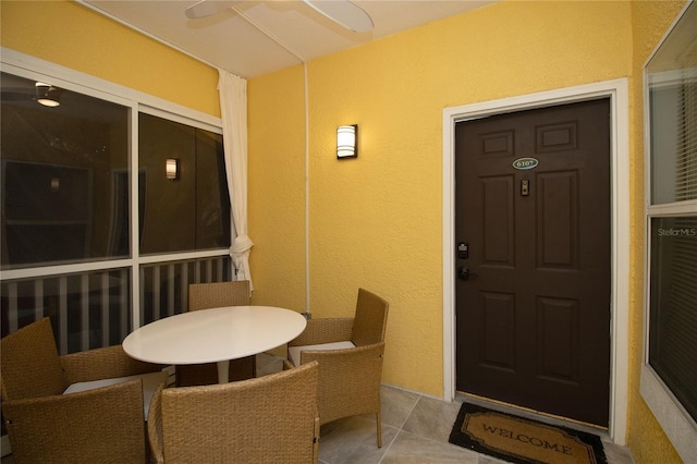 view of exterior entry with outdoor dining space and stucco siding