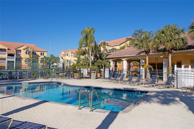 pool with fence and a patio