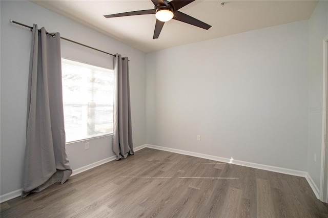 unfurnished room featuring a ceiling fan, baseboards, and wood finished floors