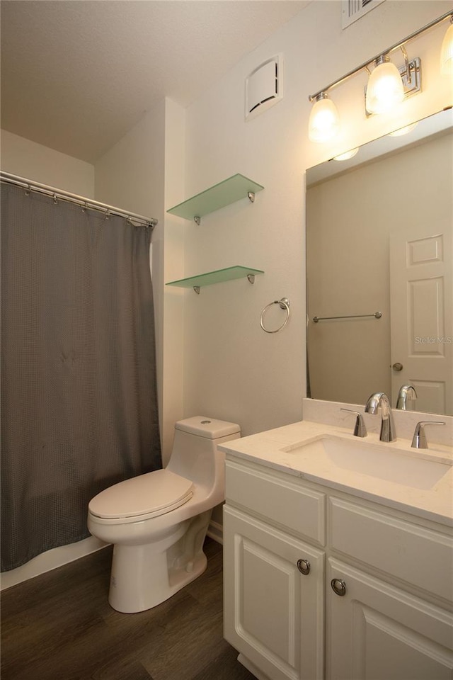 bathroom featuring a shower with shower curtain, vanity, toilet, and wood finished floors