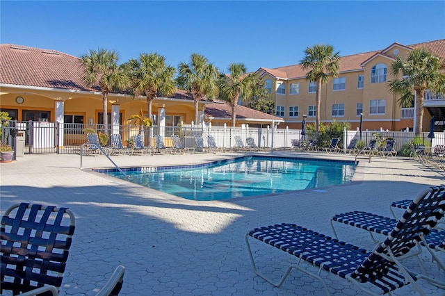 community pool with fence and a patio