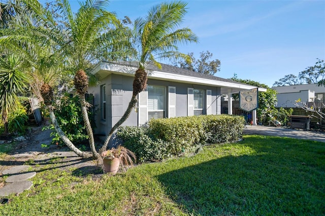 exterior space with a lawn and stucco siding