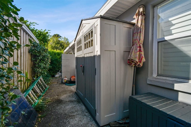 view of side of home featuring a storage shed