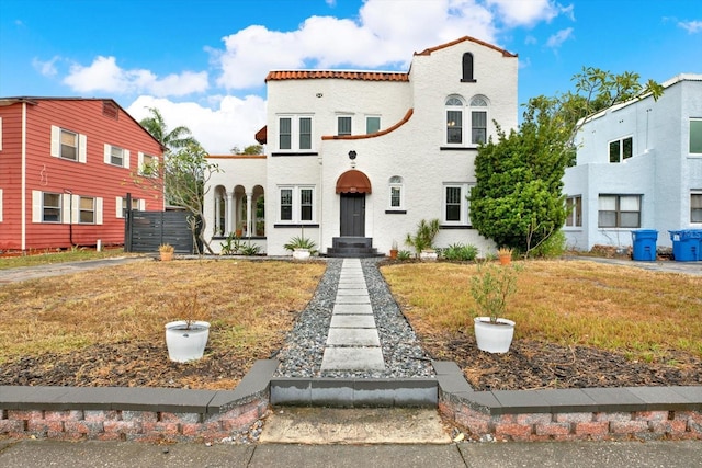 mediterranean / spanish-style home with a front lawn