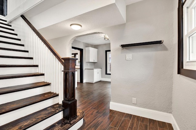 stairway featuring a textured ceiling and hardwood / wood-style flooring