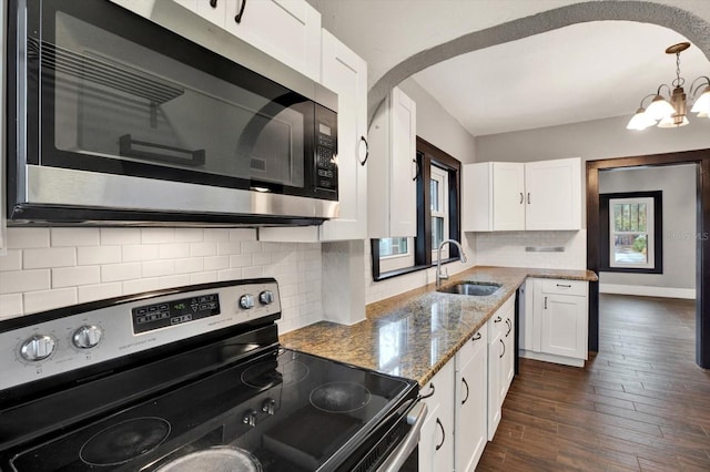 kitchen with a wealth of natural light, white cabinetry, sink, and appliances with stainless steel finishes