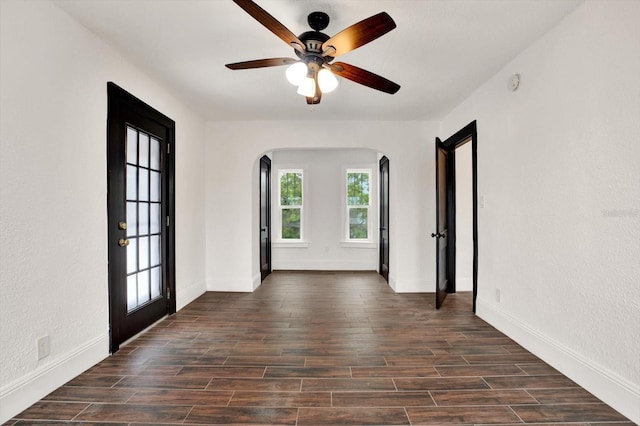 unfurnished room with ceiling fan, french doors, and dark wood-type flooring