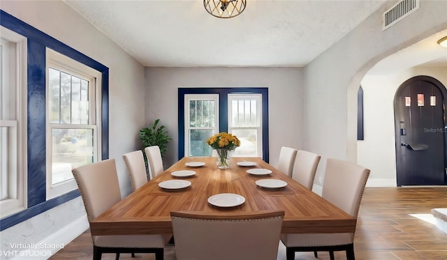 dining area featuring hardwood / wood-style flooring, a textured ceiling, and a wealth of natural light