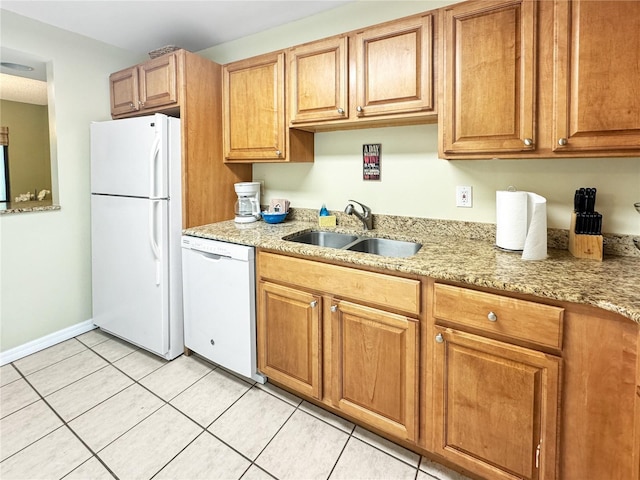 kitchen featuring light stone countertops, sink, light tile patterned floors, and white appliances