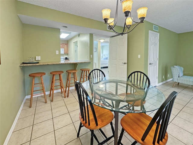 tiled dining room with a chandelier and a textured ceiling