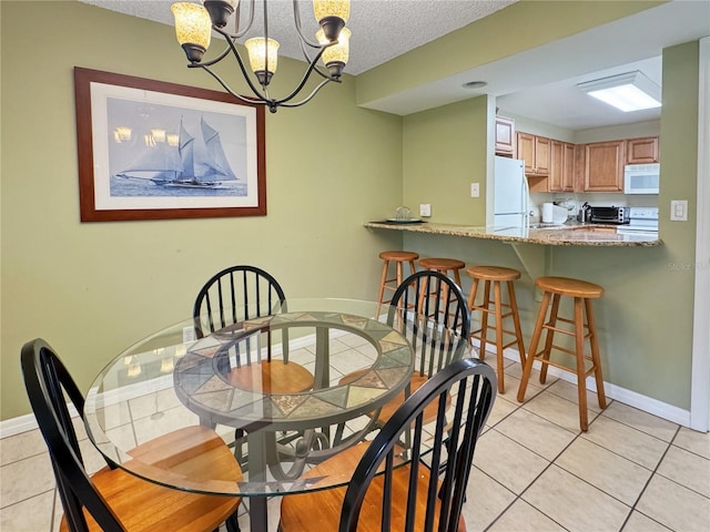 1515 Pinellas Bayway S Unit 40, Saint Petersburg, FL 33715 - dining room featuring light tile patterned floors, a chandelier, baseboards, and a textured ceiling