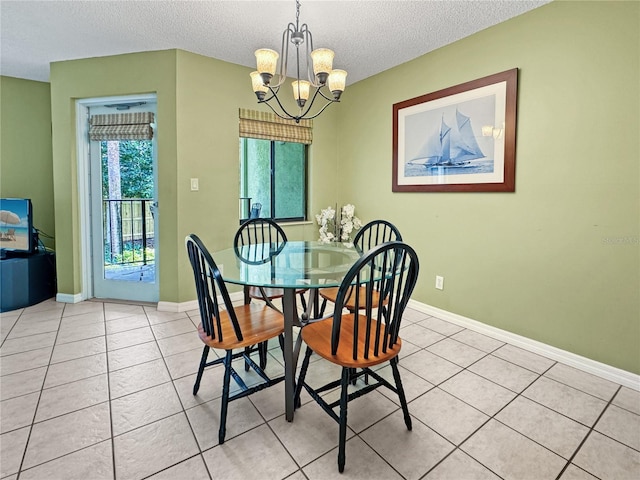 dining area with light tile patterned floors, a chandelier, and a textured ceiling