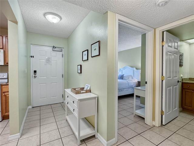 entryway featuring light tile patterned floors and a textured ceiling