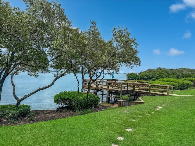 dock area with a yard and a water view