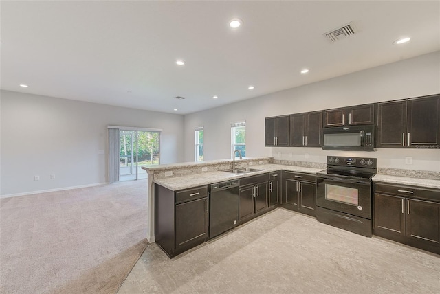 kitchen featuring visible vents, light colored carpet, a peninsula, black appliances, and a sink