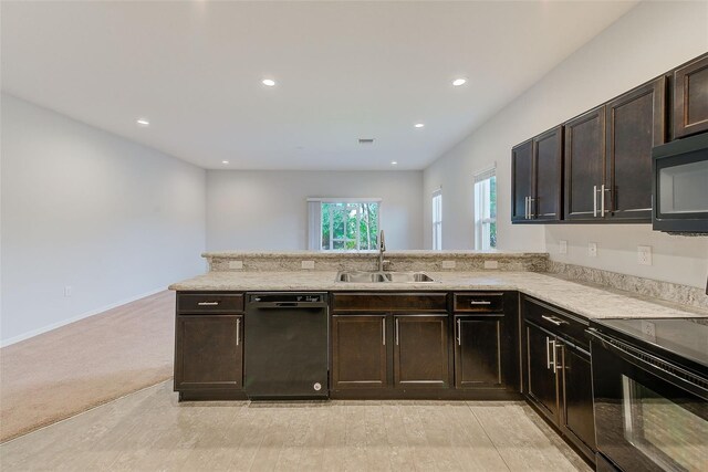 kitchen with recessed lighting, dark brown cabinetry, a sink, a peninsula, and black appliances