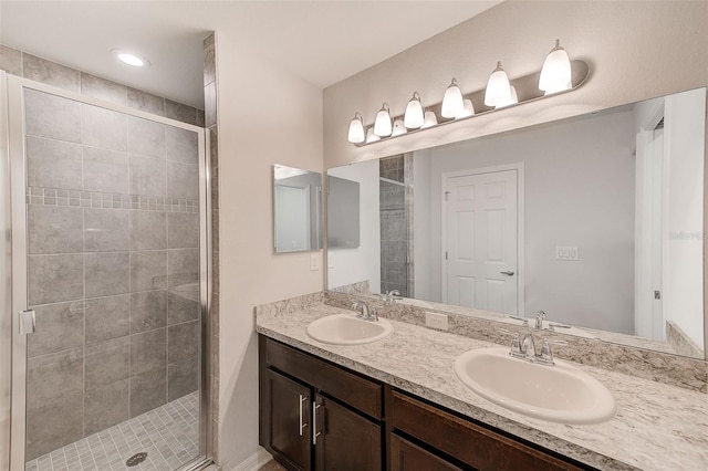 full bath with double vanity, a stall shower, and a sink