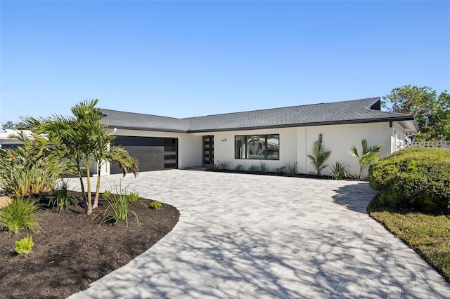 475 Island Way, Clearwater Beach, FL 33767 - view of front of house with stucco siding, a garage, and decorative driveway