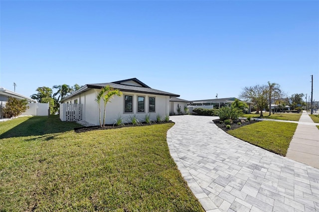 single story home featuring a front lawn