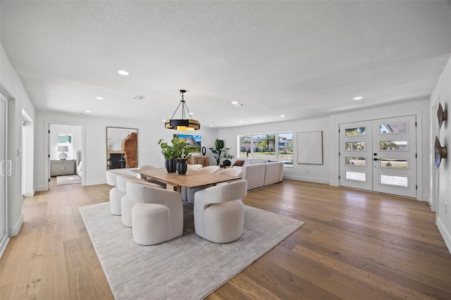 dining room featuring a textured ceiling and light wood-type flooring