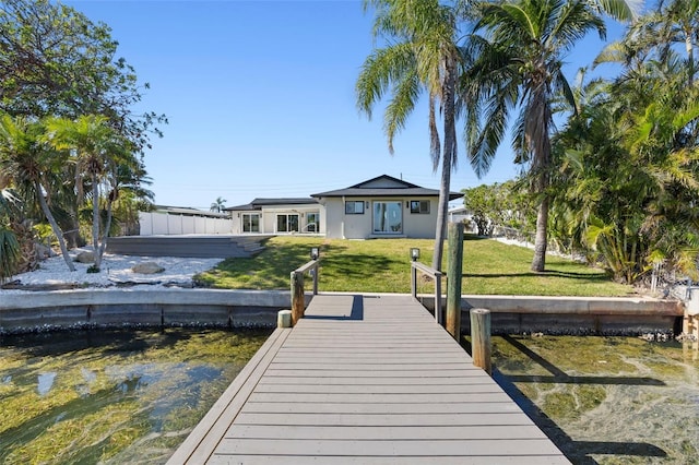 view of dock with a lawn