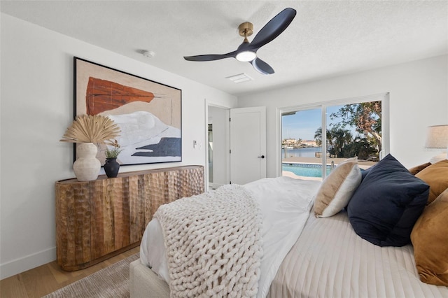 bedroom featuring ceiling fan, light wood-type flooring, a textured ceiling, and access to outside